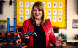 Debbie Huffine works with robotics gear in the classroom