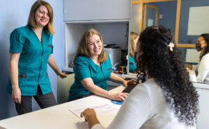 Two healthcare administrators help a patient