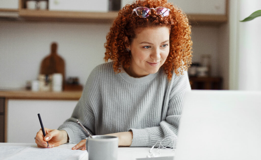 Image of woman with red curly hair and glasses propped on her head studying for an education specialist degree