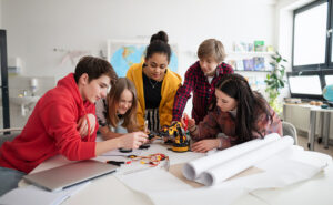 A diverse group of students working together at a table on a robotics project