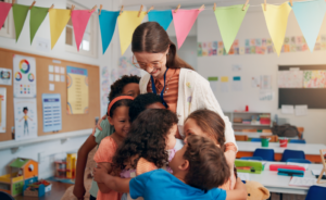 A teacher hugging her students.