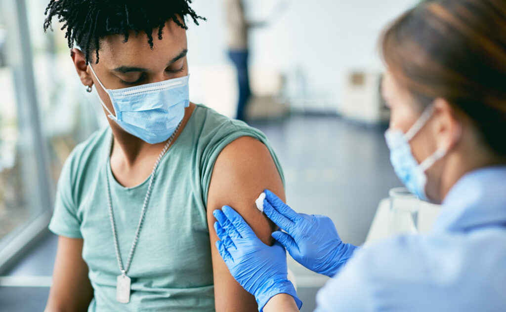 Public health professional administering a vaccine during the COVID 19 pandemic