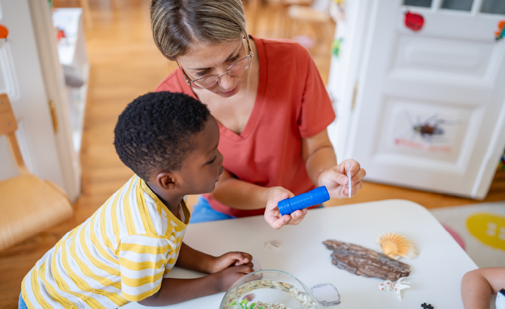 Young teacher helping a student learn about bugs.