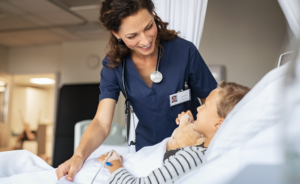 Doctor smiling and comforting a child in a hospital bed