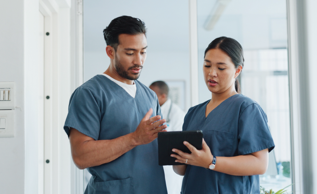 Two healthcare workers reviewing information on a tablet